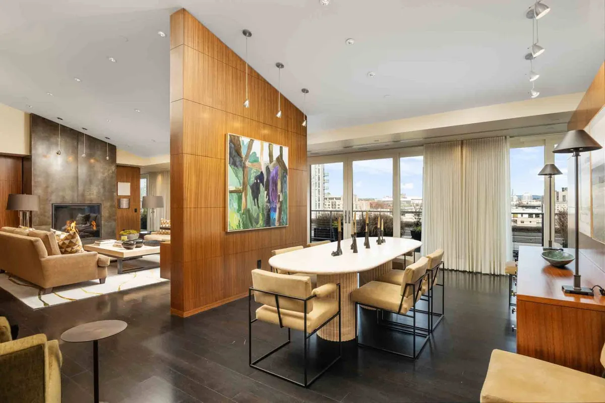 A sophisticated, cozy interior scene with an elegant dining table, plush seating, a fireplace, and a striking abstract painting. The space is designed for both formal entertaining and relaxed socializing, with an air of refinement suitable for business gatherings or intimate dinners.